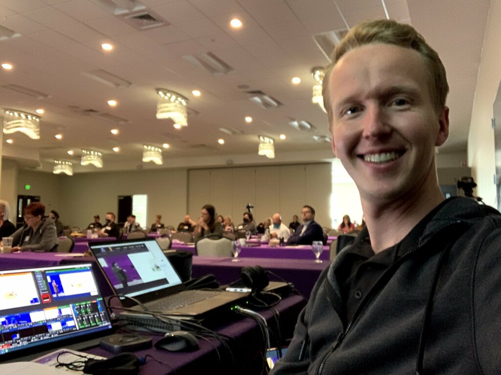 Cooper Brown smiling at a table with his event equipment.