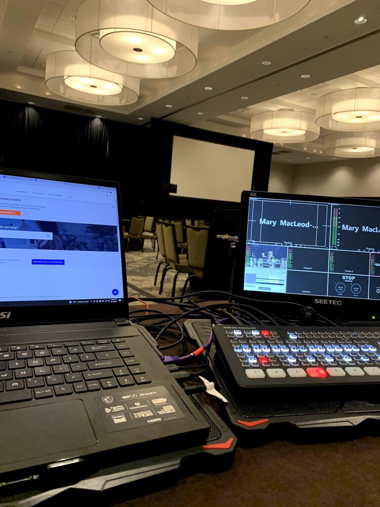 A laptop and sound board in an empty conference room.