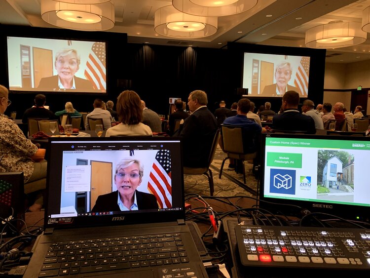 A live stream of a woman speaking broadcasted to a conference audience.