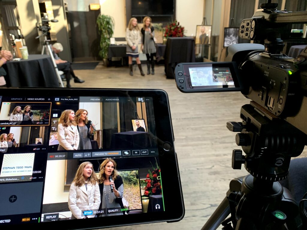 Two women being filmed as they speak at a memorial service.