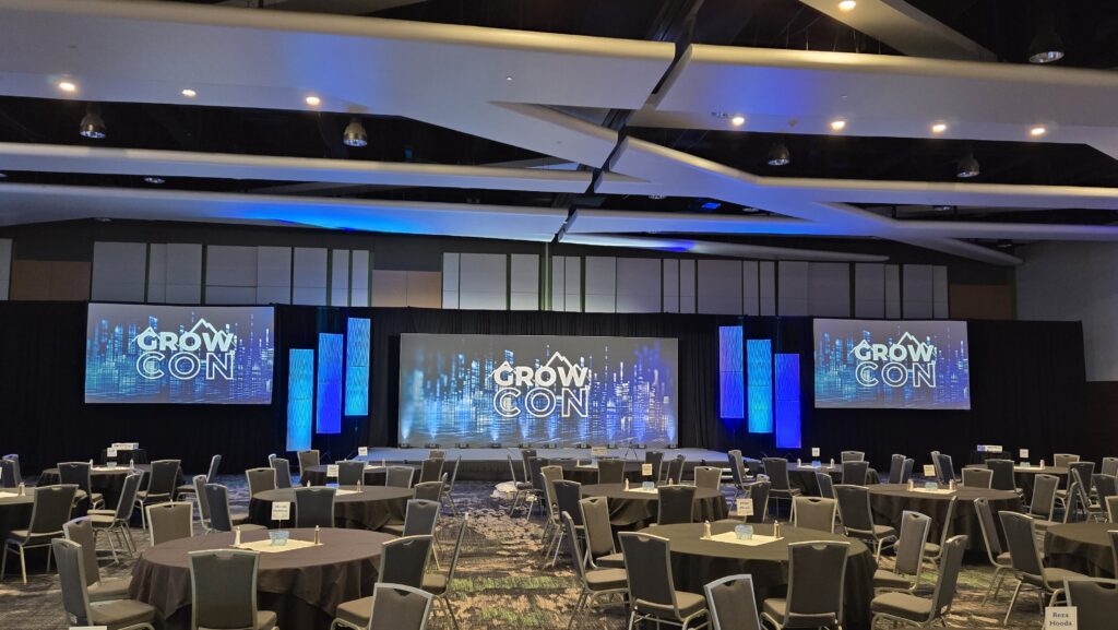 Corporate conference set up for GrowCon at the Utah Valley Convention Center in the Grand Ballroom. Cool lighting produced by Charisma Event Productions.